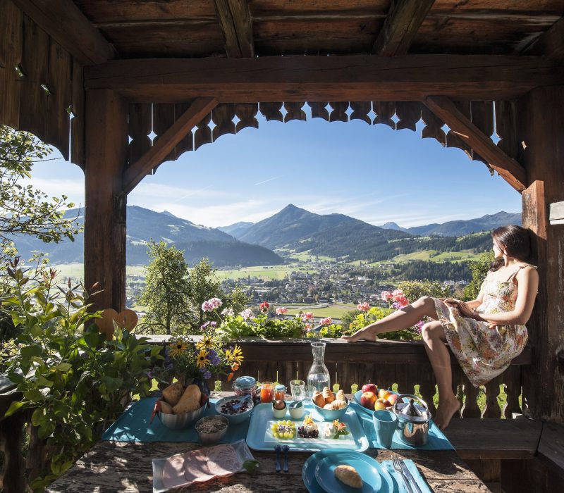 Austria, Salzburg State, Altenmarkt-Zauchense, woman enjoying view from veranda of old farmhouse